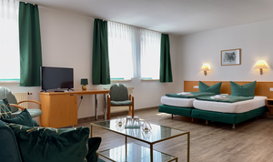 Innenansicht mit Doppelbett, Sofa und Schreibtisch, Zimmer 1